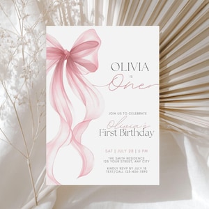 Peut inclure: Une invitation d'anniversaire rose clair avec un n&oelig;ud et des rubans &agrave; l'aquarelle. Le texte indique "Olivia a un an" et "Premier anniversaire d'Olivia". Les d&eacute;tails incluent la date, l'heure, le lieu et les informations RSVP. L'invitation est sur fond neutre.