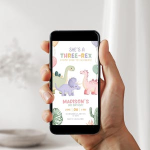 May include: A smartphone displays a colorful birthday invitation with dinosaur illustrations. The text reads "She's a Three-Rex" and includes details for a 3rd birthday celebration. The design features pastel colors and cartoon dinosaurs.