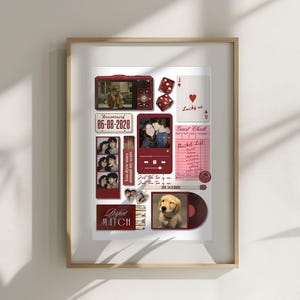 May include: A framed collage featuring various red-toned elements. Includes a small camera, dice, playing cards, photos, and a vinyl record with a puppy image. The date "06-08-2020" is displayed. The words "Perfect Match" are visible.