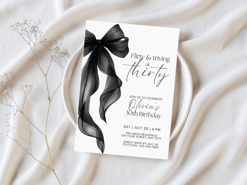 May include: A white invitation card with a black bow illustration. The text reads "Flirty & thriving at thirty" and invites guests to Olivia's 30th birthday. Includes date, time, location, and RSVP information.