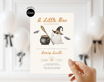 May include: Halloween baby shower invitation with the text "A Little Boo Is Almost Due." The design features a cute ghost wearing a witch hat, a cauldron, bats, and the name "Avery Smith." The invitation is held by a hand.