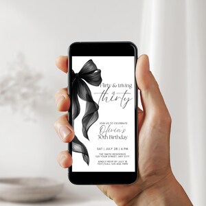 May include: A smartphone displays a black and white birthday invitation. The invitation features a black bow and the text "Flirty & thriving at thirty." Details include the date, time, location, and RSVP information for Olivia's 30th birthday.