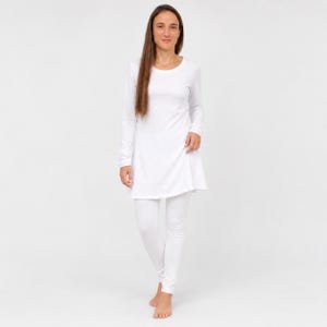 May include: A solid white long-sleeve tunic top with a rounded neckline paired with matching white leggings. The ensemble features a clean, plain design with a fitted silhouette on the leggings and a slightly flared hem on the tunic top.
