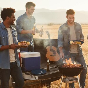 May include: Three people are enjoying a barbecue outdoors. One is grilling food on a charcoal grill, while the others hold plates of food and bottles of beer. A guitar and cooler are in the background.