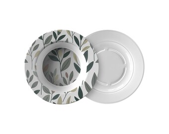 May include: Two white ceramic plates. One plate has a botanical leaf pattern in shades of green, gray, and beige. The other plate is plain white. The plates are likely for serving food.