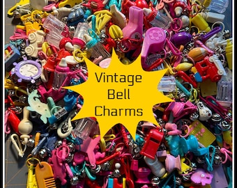 May include: A collection of colorful vintage bell charms in various shapes, including baby bottles, combs, and clocks. The charms are in shades of pink, yellow, blue, and red. Text on a yellow starburst reads "Vintage Bell Charms."