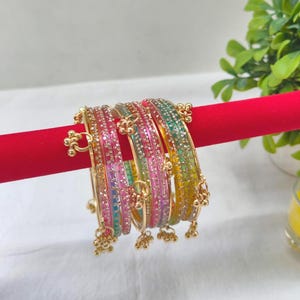 Pode incluir: Uma caneca de cerâmica branca com uma alça preta e o texto "But First, Coffee" em negrito preto. A caneca está sobre um fundo desfocado, sugerindo um ambiente acolhedor.