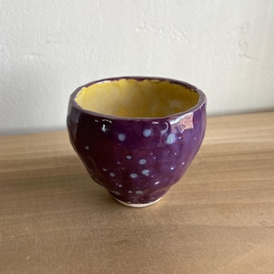 May include: A set of three ceramic mugs with a speckled, matte finish. Each mug features a different color: light blue, cream, and gray. The mugs have a simple, modern design with a rounded shape and a comfortable handle.