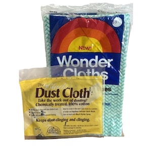 Puede incluir: Dos productos de limpieza: un paquete de "Wonder Cloths" con un diseño de arcoíris y el texto "NEW!", y un paquete amarillo de "The Black Dust Cloth" con información del producto. Los Wonder Cloths están en una bolsa de plástico transparente.