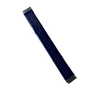 Puede incluir: Un lápiz labial Estée Lauder azul oscuro. El embalaje es azul oscuro con detalles plateados. El texto "ESTEE LAUDER LIP DEFINING PENCIL NET WT .06 OZ / 1.8 g" está impreso en el embalaje.