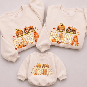 May include: Three cream-colored long-sleeve sweatshirts featuring a graphic of an orange tractor pulling a wagon of pumpkins. The text DADA, MAMA, and SOPHIA is printed in large letters with autumn-themed patterns, including plaid and pumpkin motifs.