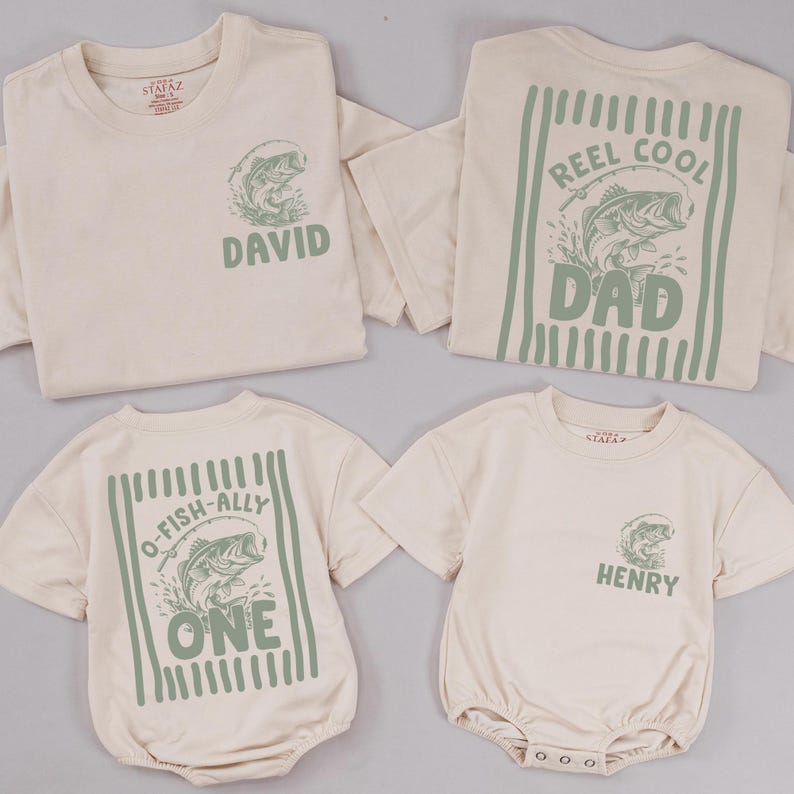 Puede incluir: Cuatro prendas de color crema que incluyen dos camisetas de manga corta y dos peleles de manga corta. Los dise&ntilde;os presentan gr&aacute;ficos en verde salvia de peces, ca&ntilde;as de pescar y texto que incluye "REEL COOL DAD", "O-FISH-ALLY ONE", "DAVID" y "HENRY".