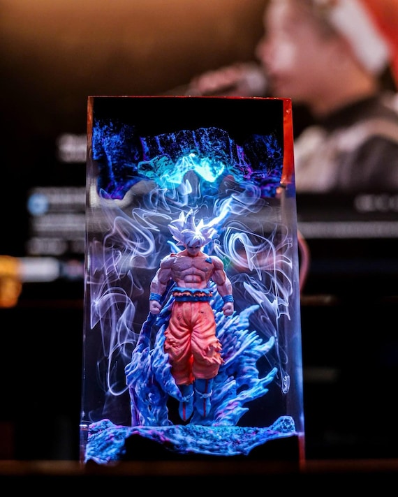A handmade Saiyan warrior encased in glowing epoxy resin on a wood base — a genuinely atmospheric desk lamp that doubles as Dragon Ball fan art.