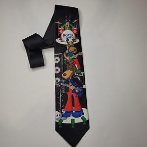 May include: Black necktie featuring a cartoon band of reindeer playing instruments. The band is on a stage with the words "ROCK ON" on the drum set. The reindeer are wearing sunglasses and colorful outfits. A festive holiday accessory.