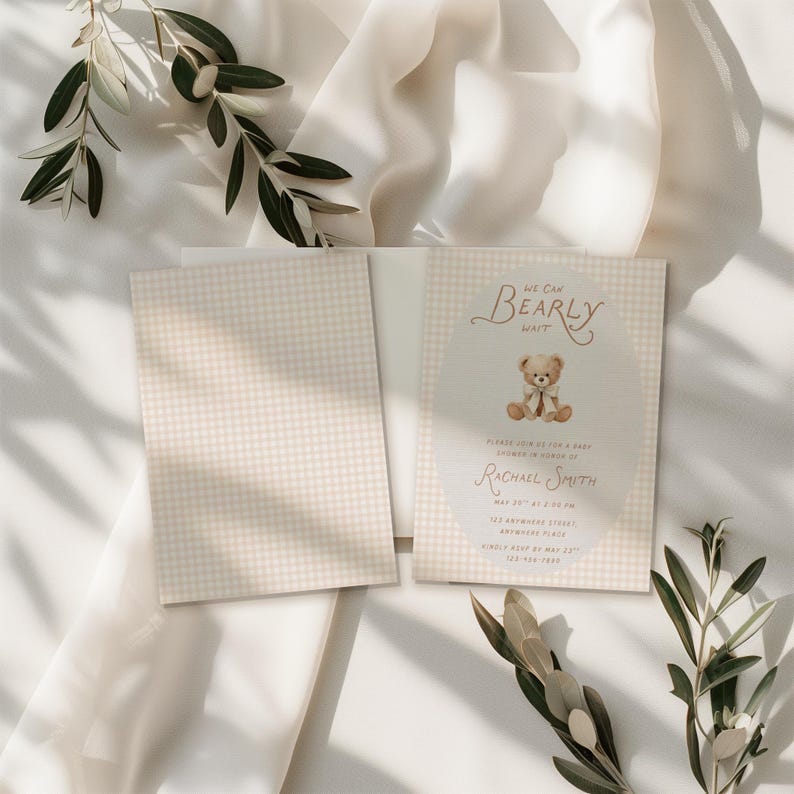 May include: A rectangular baby shower invitation card featuring a beige and white gingham pattern. The card displays a central oval containing a brown teddy bear illustration and the text: We Can Bearly Wait, Please Join Us For A Baby Shower In Honor Of Rachael Smith, May 20th At 2:00 PM, 123 Anywhere Street, Anywhere Place, Kindly RSVP By May 23rd, 123-456-7890.