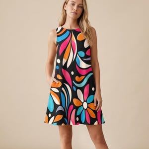 以下が含まれることがあります： ピンク、オレンジ、青、白の鮮やかな花柄が特徴のノースリーブの黒いドレス。ドレスは丸いネックラインとポケットが付いています。カラフルなデザインは、夏の日にぴったりの大胆で人目を引く外観を作り出します。