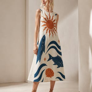 May include: A sleeveless, cream-colored midi dress featuring a printed pattern of a large orange sun, dark blue fish, dark blue waves, and orange seashells. The dress has a round neckline and a relaxed, A-line silhouette that falls below the knees.