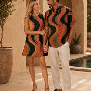 Couple standing indoors in coordinated retro wave outfits, with the woman in a mini dress and the man in a matching shirt.