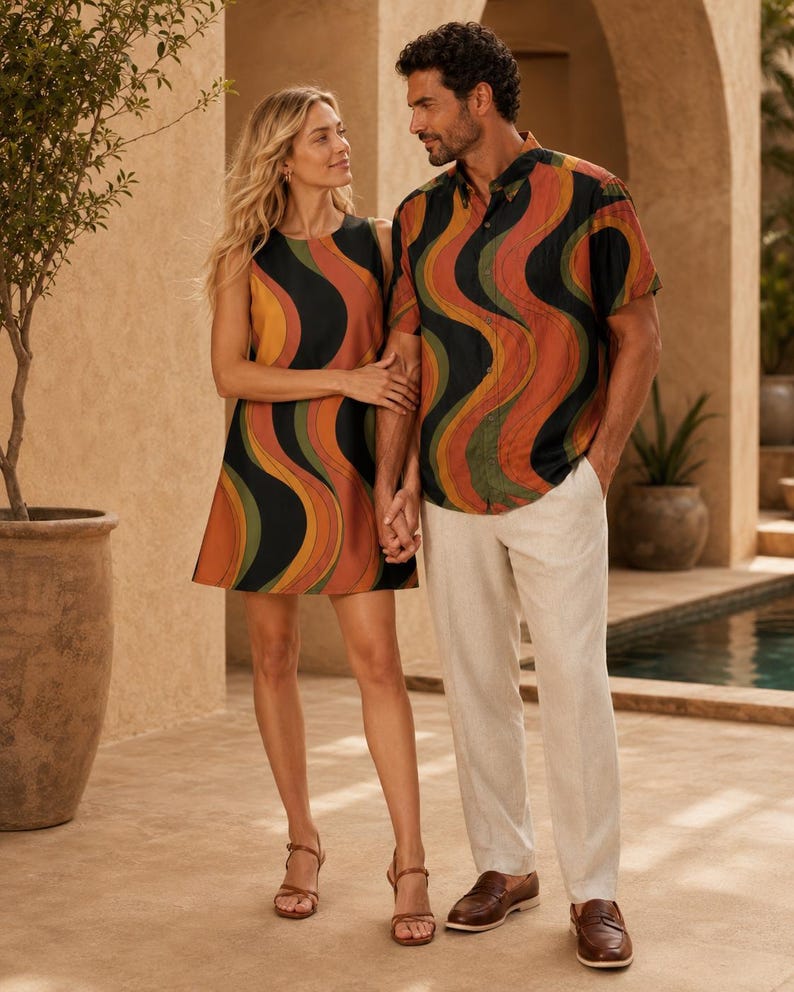 Couple standing indoors in coordinated retro wave outfits, with the woman in a mini dress and the man in a matching shirt.