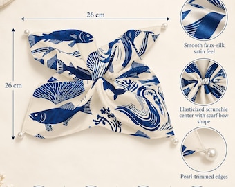 Op de afbeelding: Een vierkante sjaal van 26 cm bij 26 cm met een blauw vispatroon op een crèmekleurige achtergrond. Het heeft een elastisch scrunchie-midden, een strikvorm en randen afgewerkt met parels. De stof is 97% polyester en 3% spandex, 90 g/m².