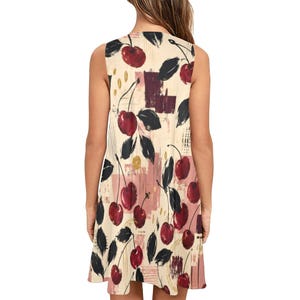 A woman from behind wearing a sleeveless cream A-line mini dress with a red and black cherry print.