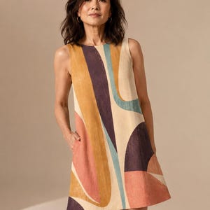 May include: A sleeveless shift dress featuring a bold, abstract pattern with large, curved shapes in shades of mustard yellow, deep purple, muted teal, and soft coral on a cream-coloured background, designed with a round neckline and side pockets.