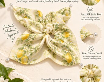 May include: A cream-colored satin hair accessory featuring a lemon and white blossom print. The square-shaped fabric has a central elastic band and four corners each adorned with a small white pearl bead. The text reads A LITTLE PIECE OF SUNSHINE.