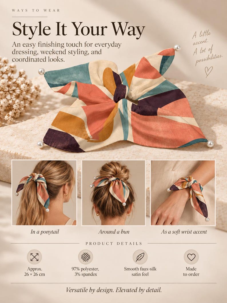May include: A square hair accessory featuring a multi-coloured abstract pattern in shades of coral, teal, cream, and dark purple. The fabric has a smooth satin finish and is accented with small white faux pearls at each corner. It measures 26 x 26 cm.