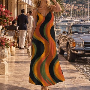 May include: A floor-length sleeveless dress featuring a repeating vertical wavy pattern in shades of orange, yellow, olive green, and black. The garment has a V-neckline, thin spaghetti straps, and a fluid, loose-fitting silhouette that falls to the ankles.