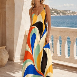 May include: A floor-length maxi dress featuring a vibrant, abstract swirl pattern in shades of orange, blue, yellow, black, and light green. The garment has thin spaghetti straps, a V-neckline, and a flowing, loose-fitting silhouette that reaches the floor.