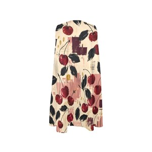 A flat lay of a cream A-line mini dress with a red and black cherry print, showing the full front of the dress.