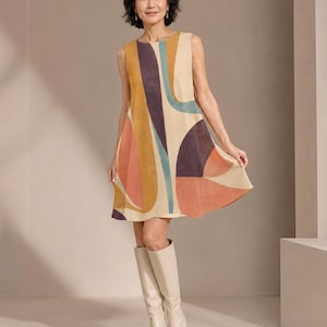 May include: A sleeveless A-line dress featuring a bold abstract pattern with curved shapes in shades of mustard yellow, deep purple, muted teal, and terracotta orange on a cream background, paired with knee-high cream leather boots.