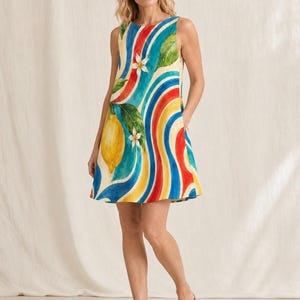 May include: A sleeveless mini dress featuring a vibrant pattern of yellow lemons, green leaves, and white blossoms set against a background of wavy, vertical stripes in shades of red, yellow, and blue. The dress has a round neckline and side pockets.