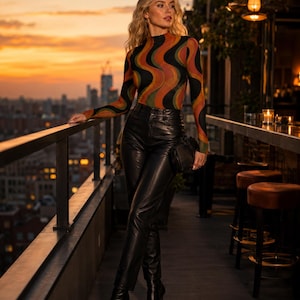May include: A long-sleeved mock neck top featuring a wavy, multi-colored pattern in shades of orange, green, and black, paired with high-waisted black leather trousers and black pointed-toe heeled boots, accessorized with a small black handbag.