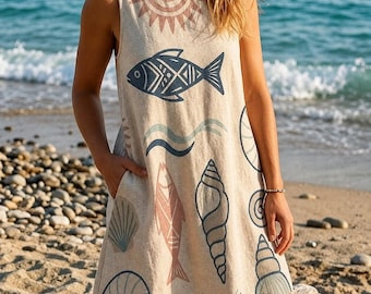 May include: A sleeveless beige shift dress featuring a repeating pattern of dark blue fish, pink fish, various seashells, and a sun motif. The dress has a round neckline and two side pockets, with a light-colored fabric texture throughout the garment.