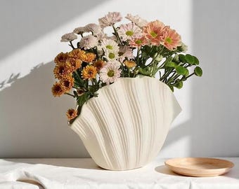 Jarrón de cerámica blanca con forma de concha: un detalle decorativo costero chic