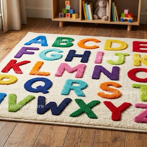 May include: A rectangular area rug with a cream-colored background featuring the alphabet in raised, multi-colored letters. Each letter is rendered in a distinct, vibrant hue including blue, green, orange, yellow, red, purple, and pink.