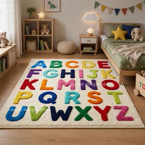 May include: A rectangular area rug featuring a cream-colored background with the English alphabet letters A through Z in various bright colors including blue, green, orange, yellow, red, purple, and pink, arranged in five rows on the floor.