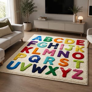 May include: A rectangular area rug with a cream-colored base featuring the English alphabet in raised, multi-colored letters. Each letter is rendered in a distinct, vibrant hue including blue, green, orange, yellow, red, purple, and pink.