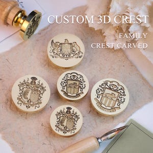 Puede incluir: Un conjunto de sellos personalizados con escudos 3D y grabados de escudos familiares. Los sellos redondos presentan diseños intrincados, con escudos, animales y elementos decorativos. Los sellos son de un material beige claro con detalles dorados.