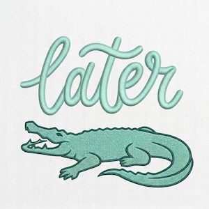 May include: An embroidered design featuring a teal alligator below the word "later" in a cursive font. The design is on a white background, creating a playful and casual aesthetic.