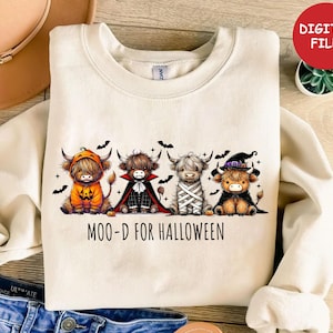 May include: Cream-colored sweatshirt featuring four Highland cows dressed in Halloween costumes. The cows are in a pumpkin costume, vampire cape, mummy wrap, and witch hat. The text "MOO-D FOR HALLOWEEN" is printed below the cows.