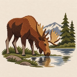 May include: An embroidery design featuring a brown moose drinking from a blue lake. The scene includes green grass, gray rocks, two dark green pine trees, and a snow-capped mountain in the background, all rendered in detailed thread work.