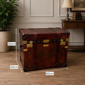 May include: A vintage-style brown leather trunk with brass hardware. The trunk measures 24 inches long, 16 inches wide, and 20 inches high. It features corner protectors, metal accents, and a classic design, suitable for storage or decor.