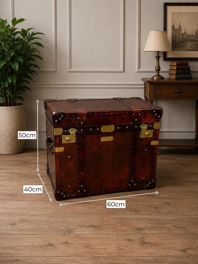 May include: A vintage-style brown leather trunk with brass hardware. The trunk measures 24 inches long, 16 inches wide, and 20 inches high. It features corner protectors, metal accents, and a classic design, suitable for storage or decor.
