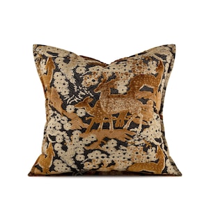 May include: Square cushion with a detailed deer and floral pattern. The cushion features a black background with tan and cream-coloured floral accents. The deer are in shades of tan and brown, creating a textured, elegant design.