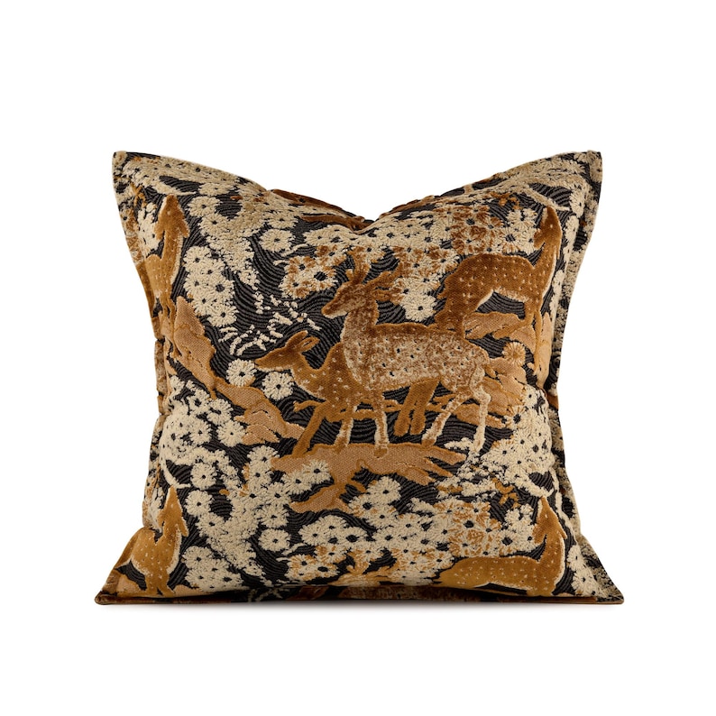 May include: Square cushion with a detailed deer and floral pattern. The cushion features a black background with tan and cream-coloured floral accents. The deer are in shades of tan and brown, creating a textured, elegant design.