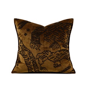 May include: A square decorative pillow with a brown and black tiger design. The pillow has a soft, velvet-like texture and a dark brown border. The tiger pattern is intricately detailed, adding a touch of elegance to the home decor.