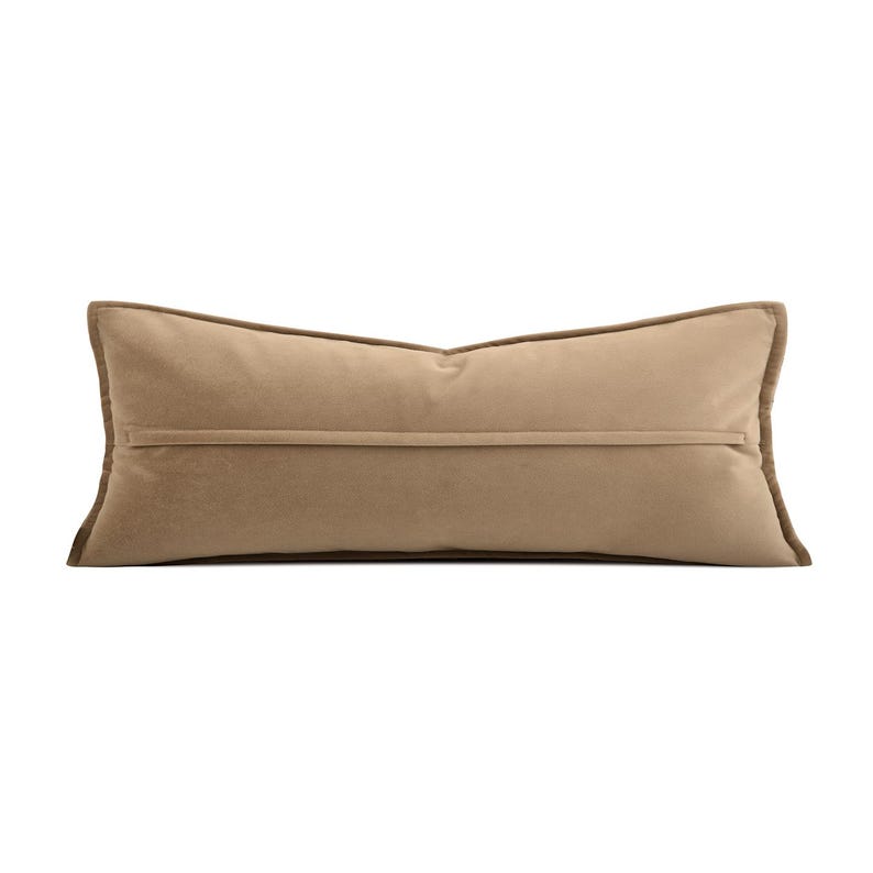 May include: A rectangular cushion in a neutral beige hue. It features a darker brown trim and a horizontal seam. This decorative cushion is designed for home decor and measures approximately 60 cm in length.