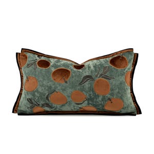 May include: A rectangular decorative pillow with a teal background and a pattern of brown oranges with dark gray leaves. The pillow has a brown border with a black trim.